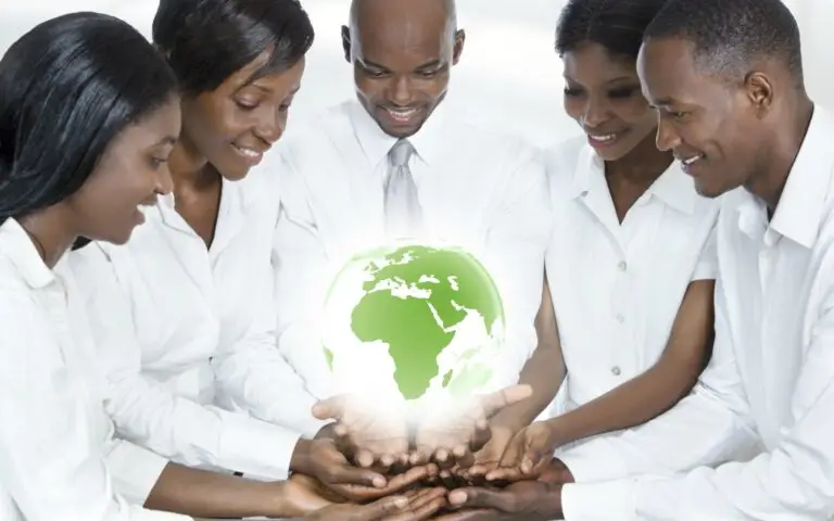 Employees working together while holding a glowing green globe, symbolizing a collaborative and supportive environment.