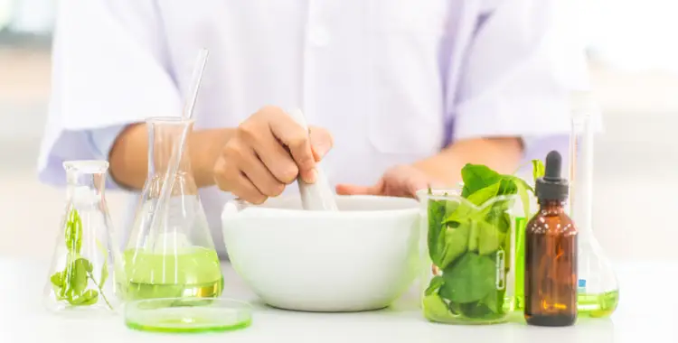 Scientist preparing herbal extracts in laboratory glassware for innovative formulations research.
