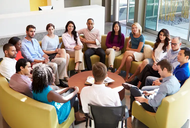 Employees sitting together in a diverse group discussion, reflecting an inclusive and respectful workplace culture.